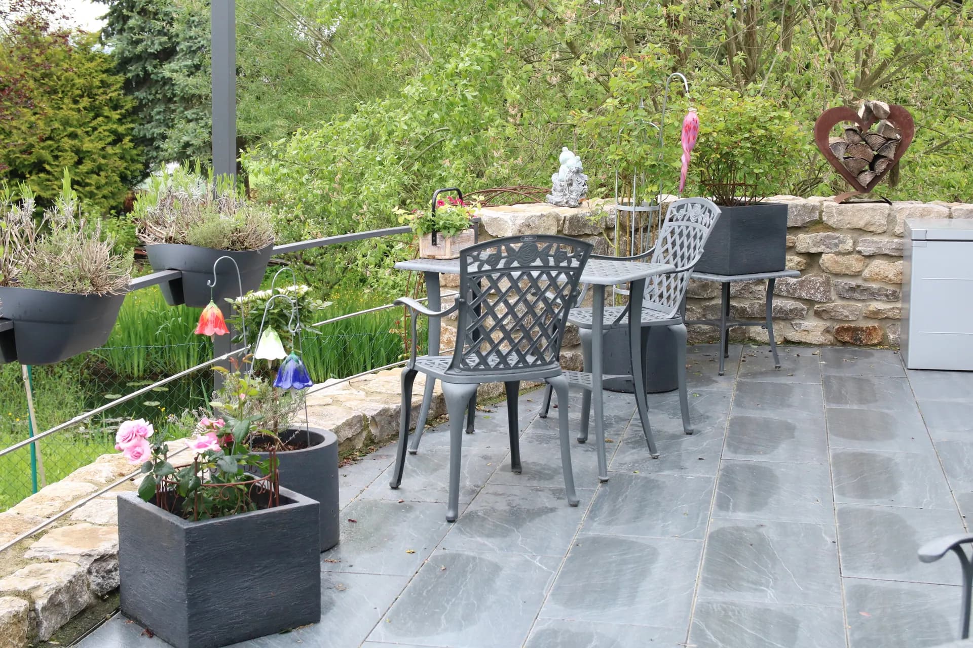 Außenanlagen: private Terrasse mit Natursteinmauer – Fertiggestellte Außenanlagen